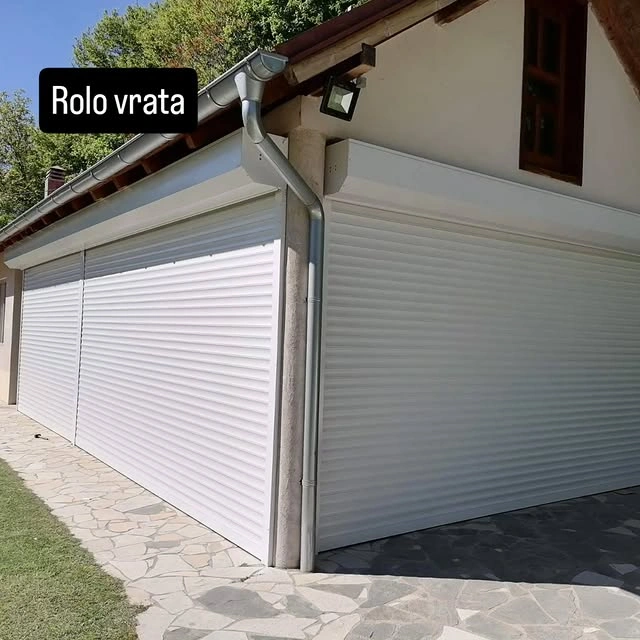 Bela rolo garažna vrata na duploj garaži porodične kuće