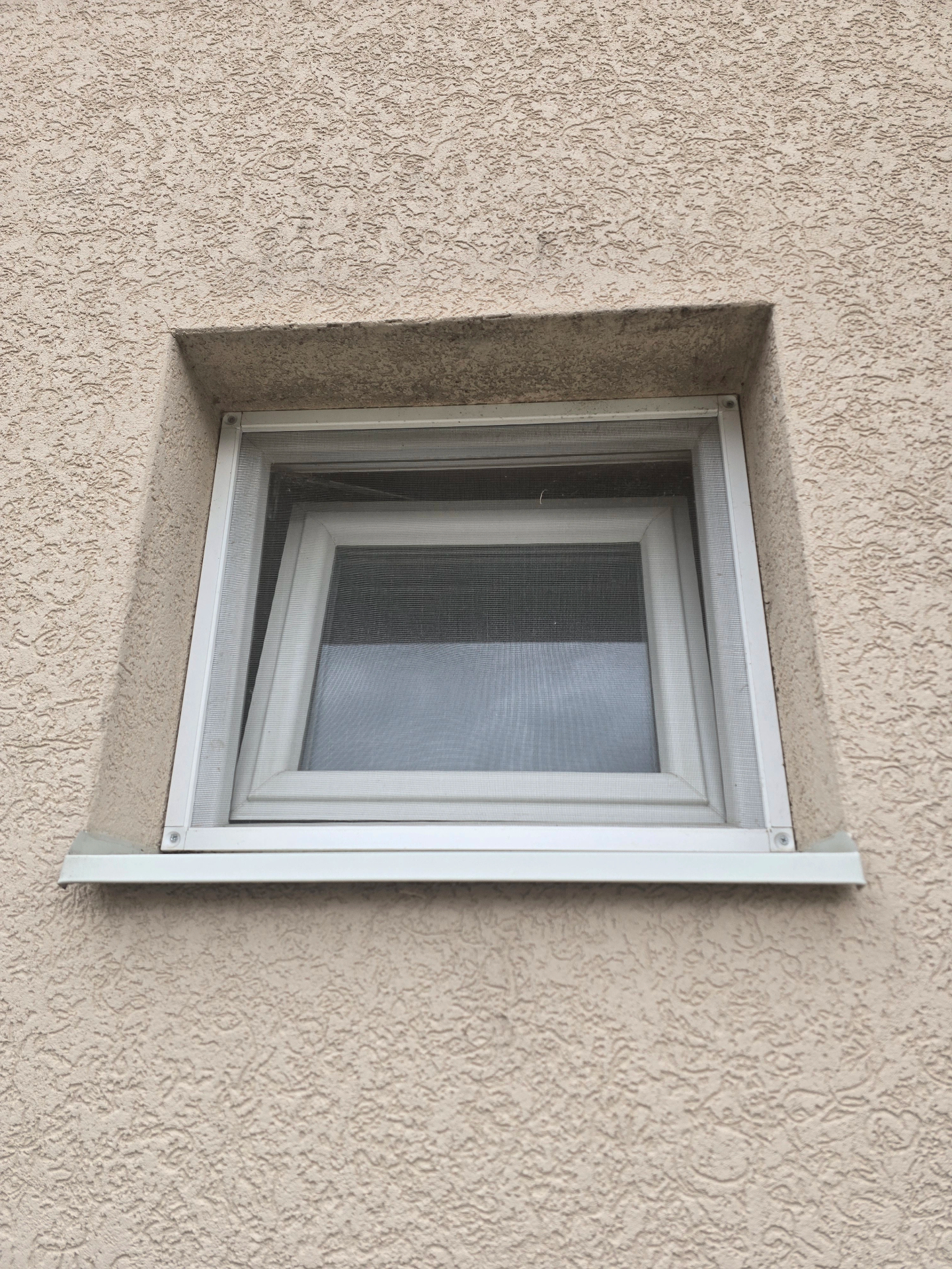 Fiksni komarnik sa belim aluminijumskim okvirom na PVC prozoru